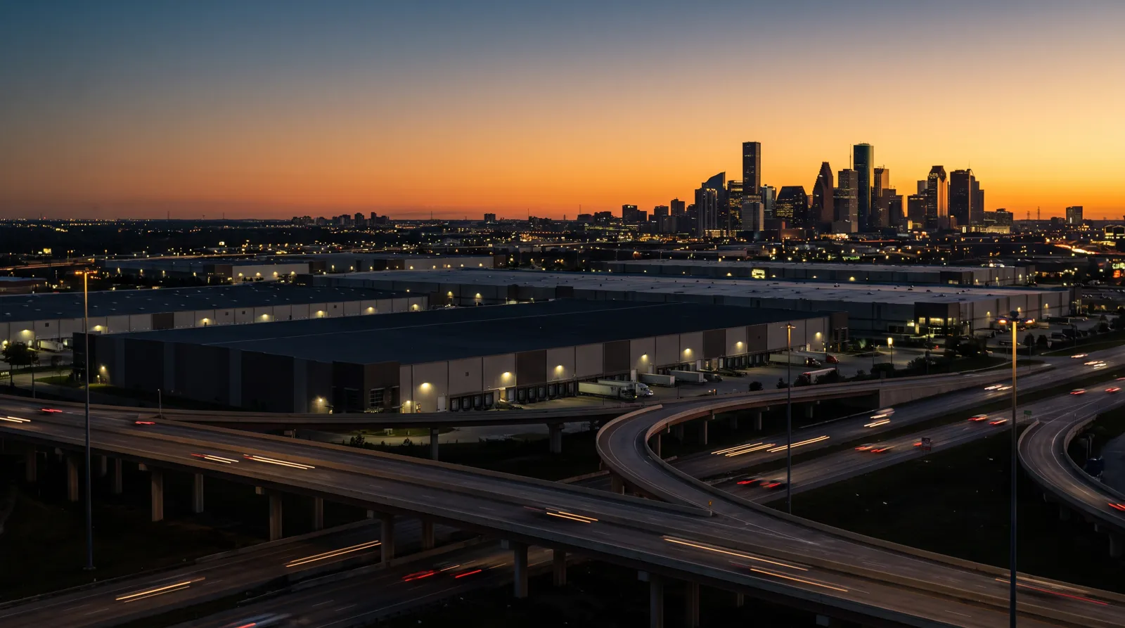 Houston industrial corridor with downtown skyline at dusk